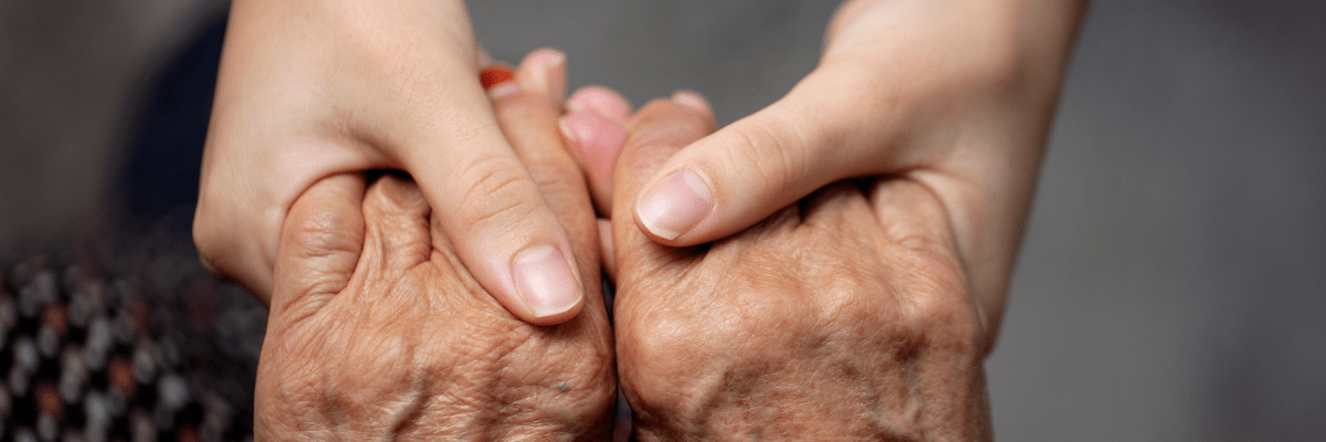die Hände eines jungen Menschen halten die Hände eines älteren Menschen